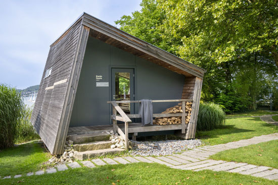 Kamin-Sauna im Saunagarten der Bodensee-Therme Überlingen mit Holzlager und direktem Blick auf den Bodensee